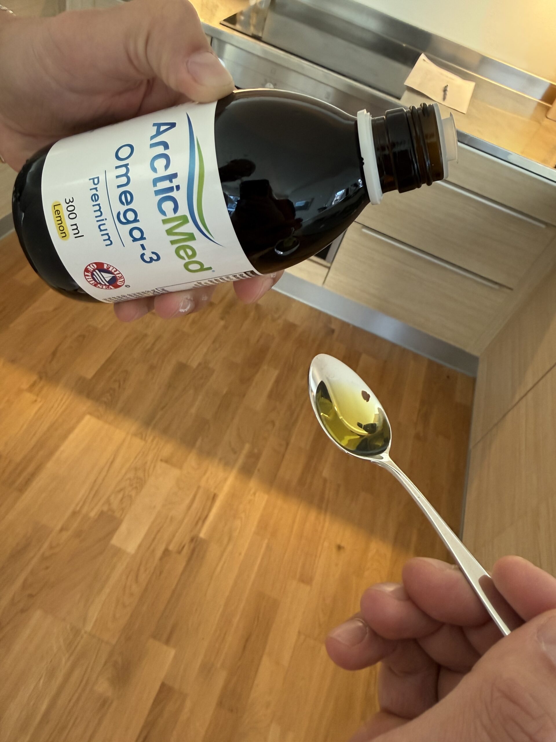 Dosering av flytande omega-3 från ArcticMed Premium Lemon på en sked, så tar jag min dagliga fiskolja